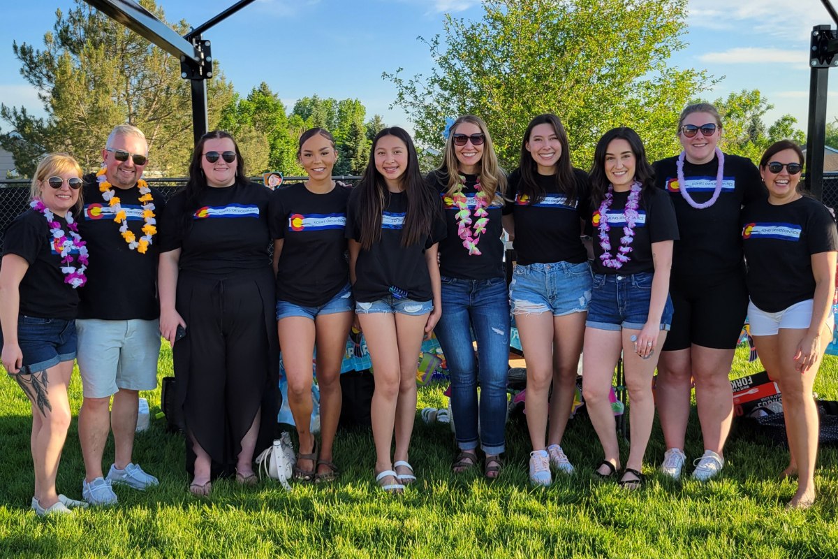 Expert, top rated Kohrs Orthodontics team wearing Hawaiian leis outside the Meadow Hills office