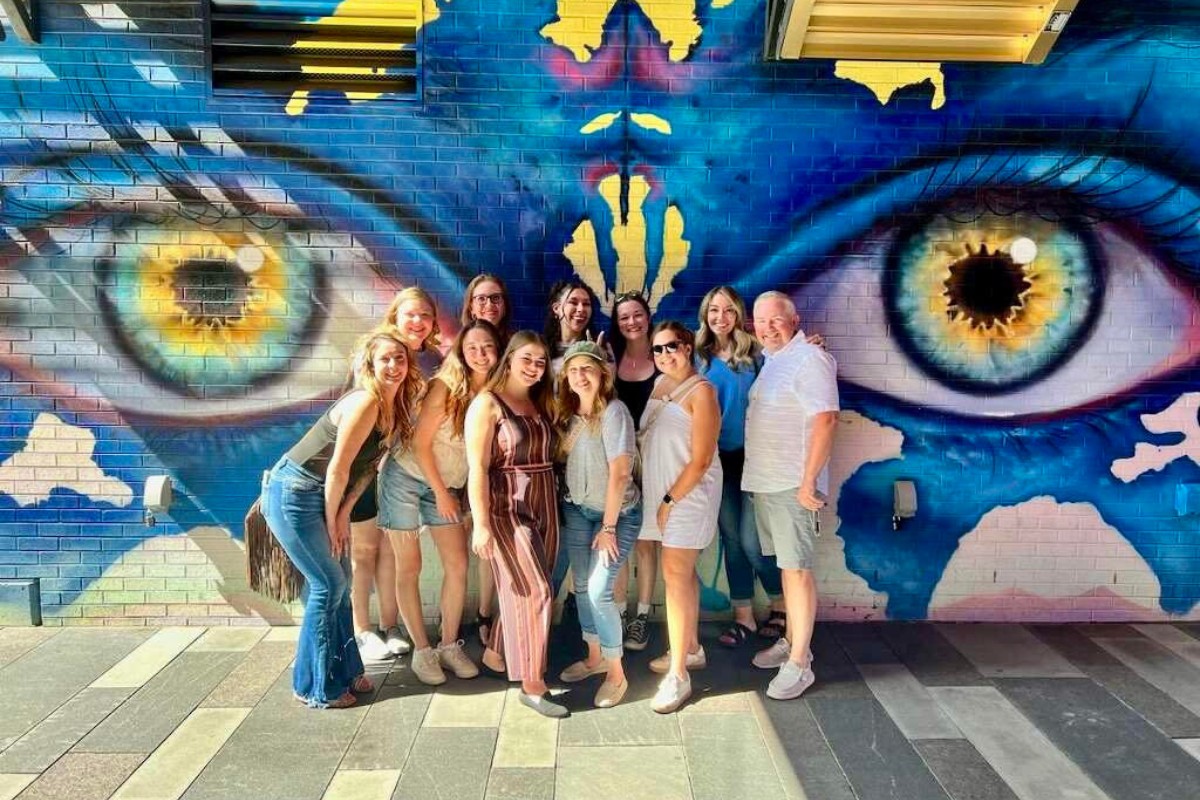 expert-orthodontics-near-southeast-crossing Expert, top rated Kohrs Orthodontics team posing in front of mural at Southeast Crossing