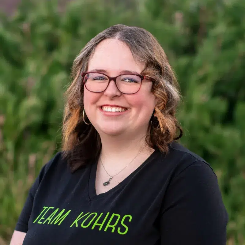 Kohrs-orthodontics-team-headshots-miranda-scheduling-coordinator Miranda at kohrs orthodontics team member with glasses smiling in outdoor portrait for orthodontic practice