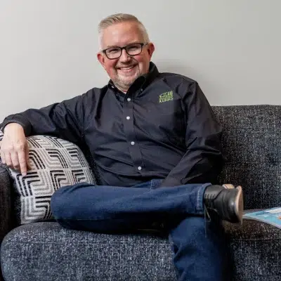 Dr. Kohrs named a topdentist by 5280 magazine for 19 years 3 Dr. Kohrs smiling and sitting on a couch, representing topdentist award